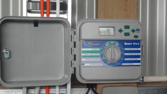 Irrigation controller with a dial and display inside an open weatherproof box