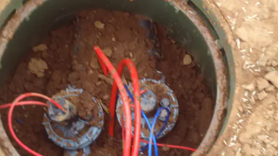 Irrigation valves and coloured wiring inside an in-ground valve box