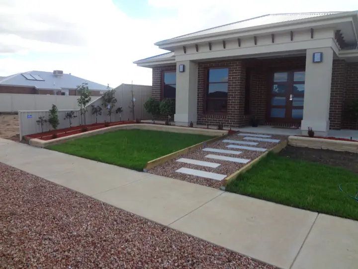 New front lawn, stepping stone path and garden beds at a finished home