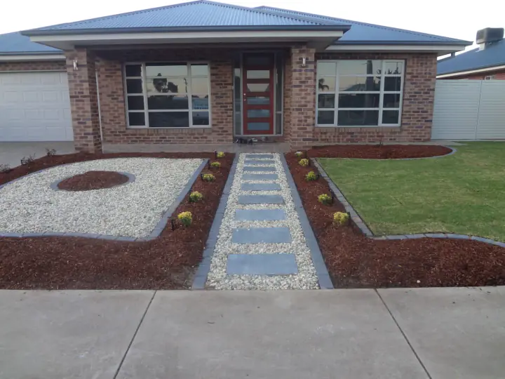 Finished front yard at a new home, with lawn, stepping stones and mulched beds