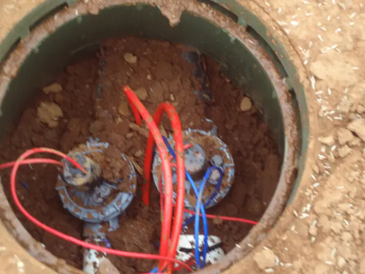Irrigation valves and coloured wiring inside an in-ground valve box